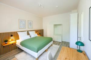 波鸿75qm Luxusapartment in perfekter Lage的卧室配有绿色和白色的床和桌子