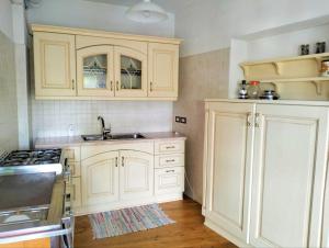 韦扎诺莫塔格乐奥比卡萨度假屋的厨房配有白色橱柜和水槽