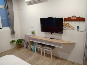 台东铁道小屋民宿 的一间设有一张桌子的房间,墙上有一台电视机