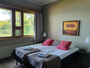 凯乌鲁Hotelli Viikinhovi的卧室配有一张大床和两个粉红色枕头