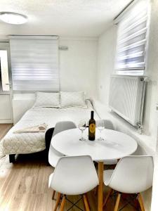 莫伊科瓦茨Pejovic apartmani Mojkovac的客房设有一张床和一张白色的桌子及椅子。