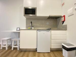 塞图巴尔Canto Doce的厨房配有白色橱柜和白色冰箱。