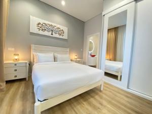 塞图巴尔Canto Doce的卧室配有一张白色大床和镜子