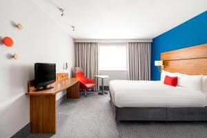 什鲁斯伯里什鲁斯伯里快捷假日酒店的酒店客房设有一张床和一张带电视的书桌。