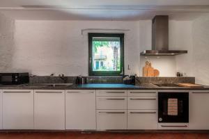 SorengoCasa Brocchi by Quokka 360 - unique design house with garden的厨房配有白色橱柜和窗户。
