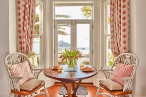 马拉扎恩Ocean Villas的一间带桌子和两把椅子的用餐室以及窗户。