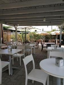 阿尔比尼娅帕尔梅酒店的庭院配有白色的桌椅和遮阳伞。