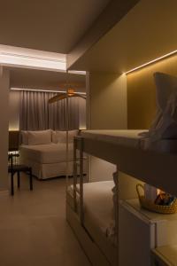 福塔莱萨Tintto Hotel的一间带两张双层床和一张沙发的卧室