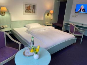 阿勒斯贝格兰姆威瑟斯酒店的酒店的客房 - 带一张床和一张桌子及一瓶