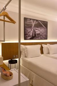 福塔莱萨Tintto Hotel的酒店客房,配有一张床和一张风车照片