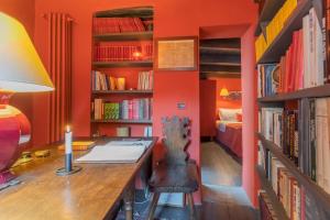 布里维奥La Corte Degli Artisti by Rent All Como的橙色客房,配有带台灯的书桌和书籍