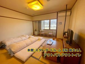 由布市湯布院 旅館 やまなみ Ryokan YAMANAMI的一间设有床铺和电视的房间