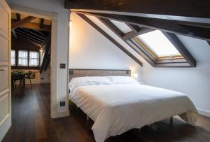 卢安科Aticos La Riba的卧室配有一张白色大床和天窗