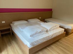 LuseveraRifugio Pian dei Ciclamini的配有2张床的带白色床单和枕头的客房