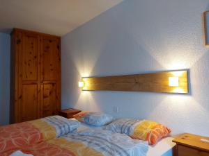 卡森里德B&B Alpenrösli的卧室配有一张床,墙上有灯