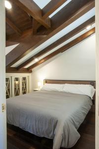卢安科Aticos La Riba的卧室配有白色的床铺和木制天花板