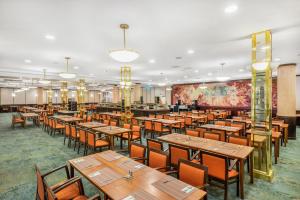 布达佩斯Danubius Hotel Hungaria City Center的用餐室配有木桌和椅子