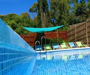 阿尔赫西拉斯康布里乡间赫塔格朗德酒店的一个带躺椅和蓝伞的游泳池