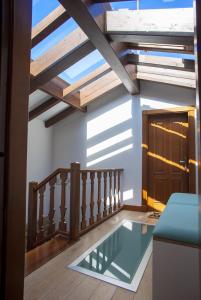 卢安科Aticos La Riba的一间设有横梁天花板的客房的玻璃地板