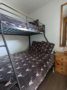 马尼戈Combe Blanche 1217的一间卧室配有一张双层床和白色马匹床单。