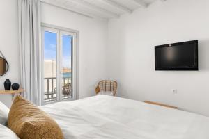 凯勒里瓦迪佩内洛普村酒店的一间卧室设有一张床、一台电视和一个阳台。