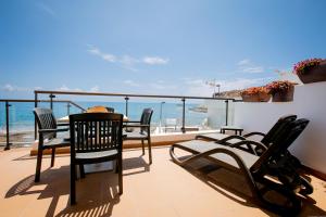 阿德耶Apartments La Caleta Sunrises的一个带桌椅的海景阳台