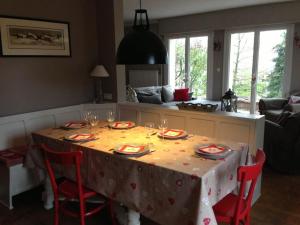 利克维Villa de charme Alsace - Riquewihr的餐桌,餐桌上配有带酒杯的桌布