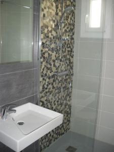 利克维Villa de charme Alsace - Riquewihr的一间带水槽和玻璃门淋浴的浴室