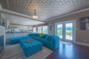 吉布森斯Iconic 3-Story Waterfront 'Marina House' w/ View的一间带蓝色沙发的客厅和一间厨房