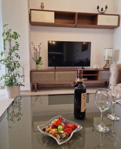 杜布罗夫尼克Luxury Apartment Moobl - Free parking的玻璃桌旁的一瓶葡萄酒和一碗食物