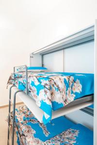 CaltabellottaLA MANDORLA Luxury Rooms的配有蓝色和白色寝具的双层床