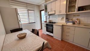特拉布宗Large Duplex Penthouse - 5 Rooms - 2 Bathrooms - SeaView - Hagia Sophia的厨房配有桌子和炉灶。 顶部烤箱