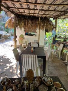 圣玛尔塔La Cima Tayrona的稻草伞下的餐桌和椅子