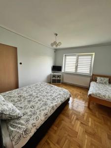 瓦多维采Apartament Wojska Polskiego 45的一间卧室配有一张床、一张桌子和两个窗户