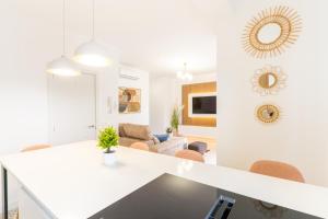 阿尔么丽亚Expoholidays- Apartamento Federico García Lorca的一间厨房和客厅,配有白色的墙壁和桌子