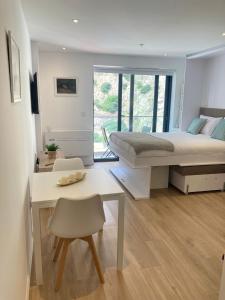 直布罗陀CP luxury studio的一间卧室配有一张床、一张桌子和一张桌子