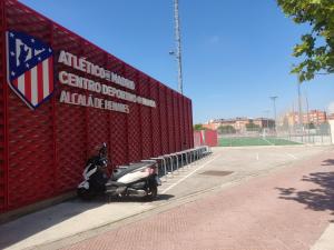 阿尔卡拉德荷那利斯WANDA Patrimonio parking gratis LICENCIA TURISTICA VT-13975的一辆摩托车停在红墙旁边