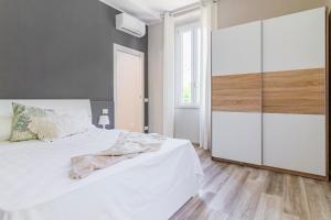 L'amoruccio的卧室配有白色的床和大衣柜。