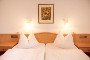 雷特温克尔豪斯洛佛塔尔宾馆的配有白色枕头的酒店客房内的两张床
