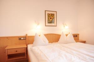 雷特温克尔豪斯洛佛塔尔宾馆的一张带白色床单的床和两张灯