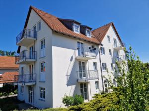 梅森希尔本奈申酒店的带阳台和树木的白色公寓大楼