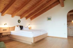 雷特温克尔豪斯洛佛塔尔宾馆的一间卧室设有一张大床和木制天花板。