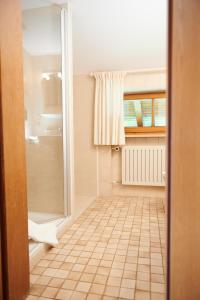 雷特温克尔Haus Sonnwies的带淋浴的浴室和瓷砖地板。