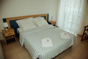皮加迪卡阿萨酒店的一间卧室配有一张床,上面有两条毛巾