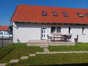 KővágóörsOrbán nyaralóház的白色的房子,有橙色的屋顶和桌子