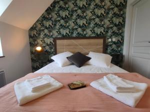 CoutansouzeAuberge des Colettes的一间卧室配有一张床,上面有两条毛巾
