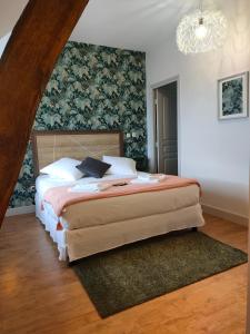 CoutansouzeAuberge des Colettes的一间卧室设有一张大床和墙壁
