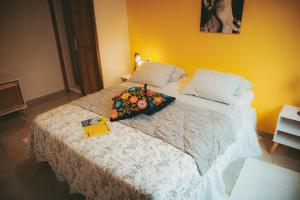 里约热内卢Eco Pousada Estrelas da Babilônia的一间卧室配有一张带一束鲜花的床