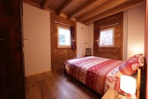 巴切诺Casa Vacanze Le Falesie的一间卧室设有一张床和两个窗户。