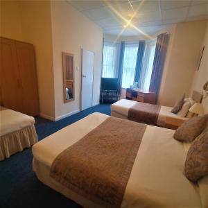 伯恩茅斯伯利府酒店的一间酒店客房,房间内设有两张床